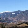 Von der Pfarrkirche von Burgstall mit unbekannten Ruinen im Vordergrund und der schneebedeckten Hochwart im Hintergrund.